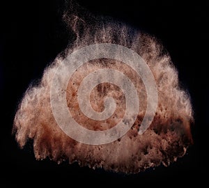 Brown powder tornado over dark background