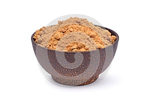 Brown raw cane sugar in wooden bowl