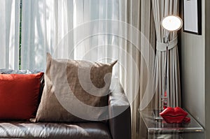 Brown and red pillow on brown sofa