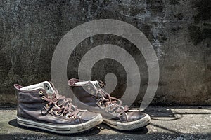 Brown Retro High Top Canvas Sneakers was placed on old cement floor. Vintage age-worn sneakers canvas shoes brown photo