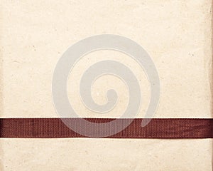 Brown ribbon over vintage gift old paper background