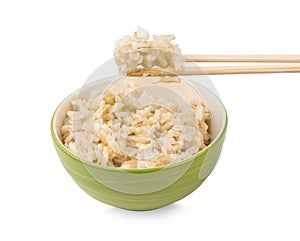 Brown rice with chopsticks in a cup on white background