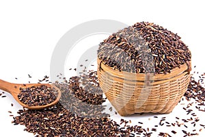 Brown rice or riceberry in bamboo basket and wooden spoon isolated on white background