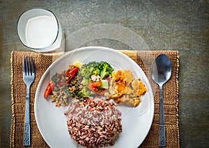 Brown rice with side dish and milk.