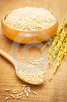 Brown rice on wooden spoon and bowl