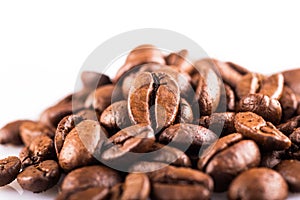 Brown roasted coffee beans close up on white background