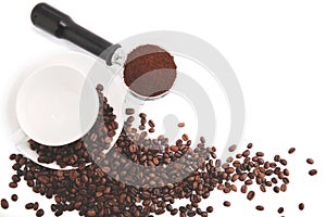 Brown roasted coffee beans on the .Coffee saucer and .Coffee powder on the potta filter on white background