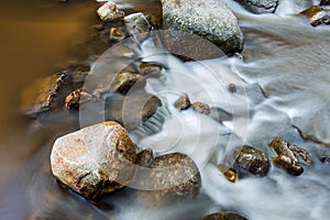 Brown rock watercourse with flowing water photo