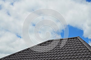 Brown roof tiles or shingles on house as background image. New overlapping brown classic style roofing material texture pattern o