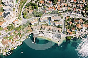 Brown roofs of the Huma Kotor Bay Hotel with a private beach. Dobrota, Montenegro. Drone