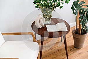 Brown round coffee table with empty notebook and ceramic vase