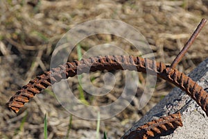 Brown rusty curved iron rebar in the street