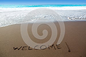 Brown sand beach with written word Welcome