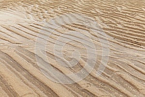 Brown sand curls after the sea water recedes pattern and background texture