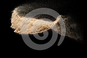 Brown sand explosion isolated on black background. Freeze motion of sandy dust splash.Sand texture concept