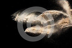 Brown sand explosion isolated on black background. Freeze motion of sandy dust splash.Sand texture concept