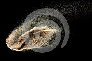 Brown sand explosion isolated on black background. Freeze motion of sandy dust splash.Sand texture concept