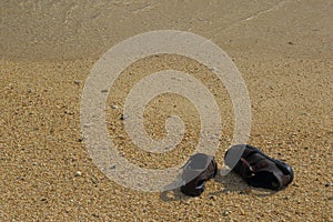 Brown sandals on a deserted beach