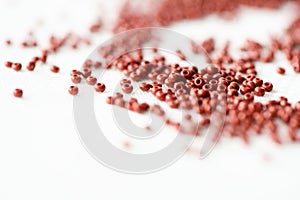 Brown seed beads on textile background close up