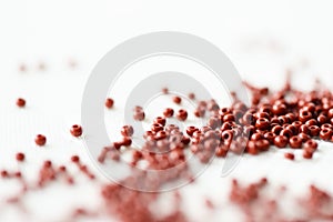 Brown seed beads on textile background close up