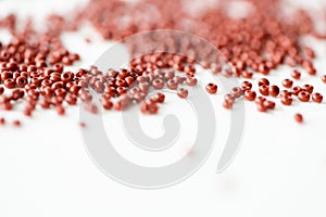 Brown seed beads on textile background close up