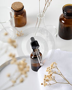 Brown serum dropper bottle with relaxing aroma flower and laboratory flask