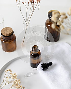 Brown serum dropper bottle with relaxing aroma flower and laboratory flask