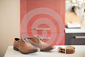 Brown shoes and belt await the anticipating groom, wedding decor