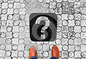 Brown shoes standing on the floor with question mark - meaning of life - next travel destination