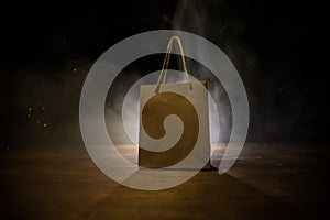 Brown shopping bag with handles placed on dark desktop. Shopping concept