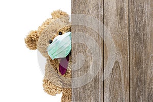 Brown sick teddy bear with protective medical facemask