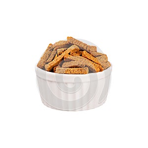 Brown sliced rye bread sticks as croutons in white ceramics bowl isolated on white background.