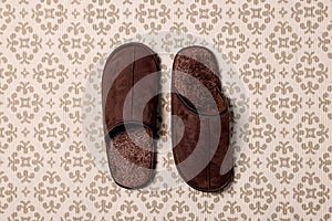 Brown slippers on patterned carpet