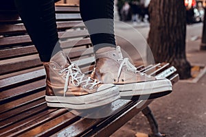 Brown slippers with white laces on wooden chair