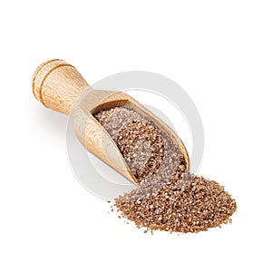 Brown smoked salt in a wooden scoop on white background