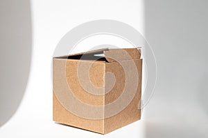 Brown square corrugated cardboard box on a white background. Added shadows, copy space