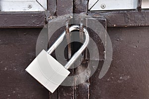 Brown steel door with padlock, Locked.