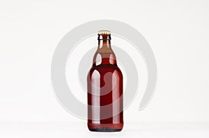 Brown steinie belgian beer bottle 330ml mock up. Template for advertising, design, branding identity on white wood table.