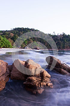 Brown stones on tropical sand beach at dusk