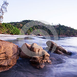 Brown stones on tropical sand beach at dusk