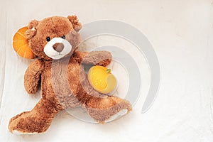 Brown stuffed toy teddy bear with pumpkin on sackcloth fabric texture