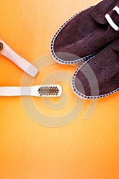 Brown suede espadrille shoes with brushes on yellow paper background.