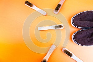 Brown suede espadrille shoes with brushes on yellow paper background.