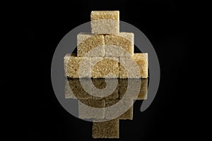 Brown sugar cube isolated on black glass