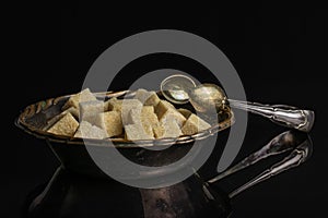 Brown sugar cube isolated on black glass