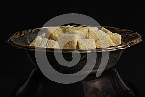 Brown sugar cube isolated on black glass