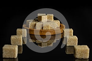 Brown sugar cube isolated on black glass