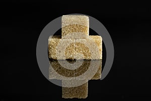 Brown sugar cube isolated on black glass