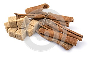 Brown sugar cubes and cinnamon sticks on a white isolated background