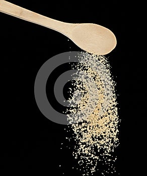 Brown Sugar fall, brown grain sugar pouring down abstract cloud fly from wooden spoon. Beautiful complete seed sugarcane, food